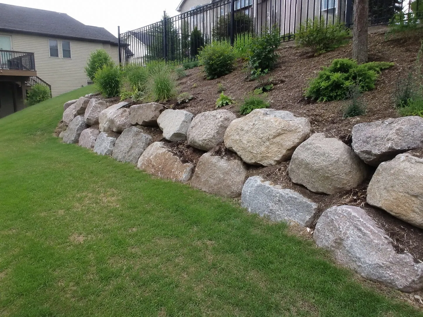 Boulder retaining wall on an exposed coastal slope on Waiheke Island